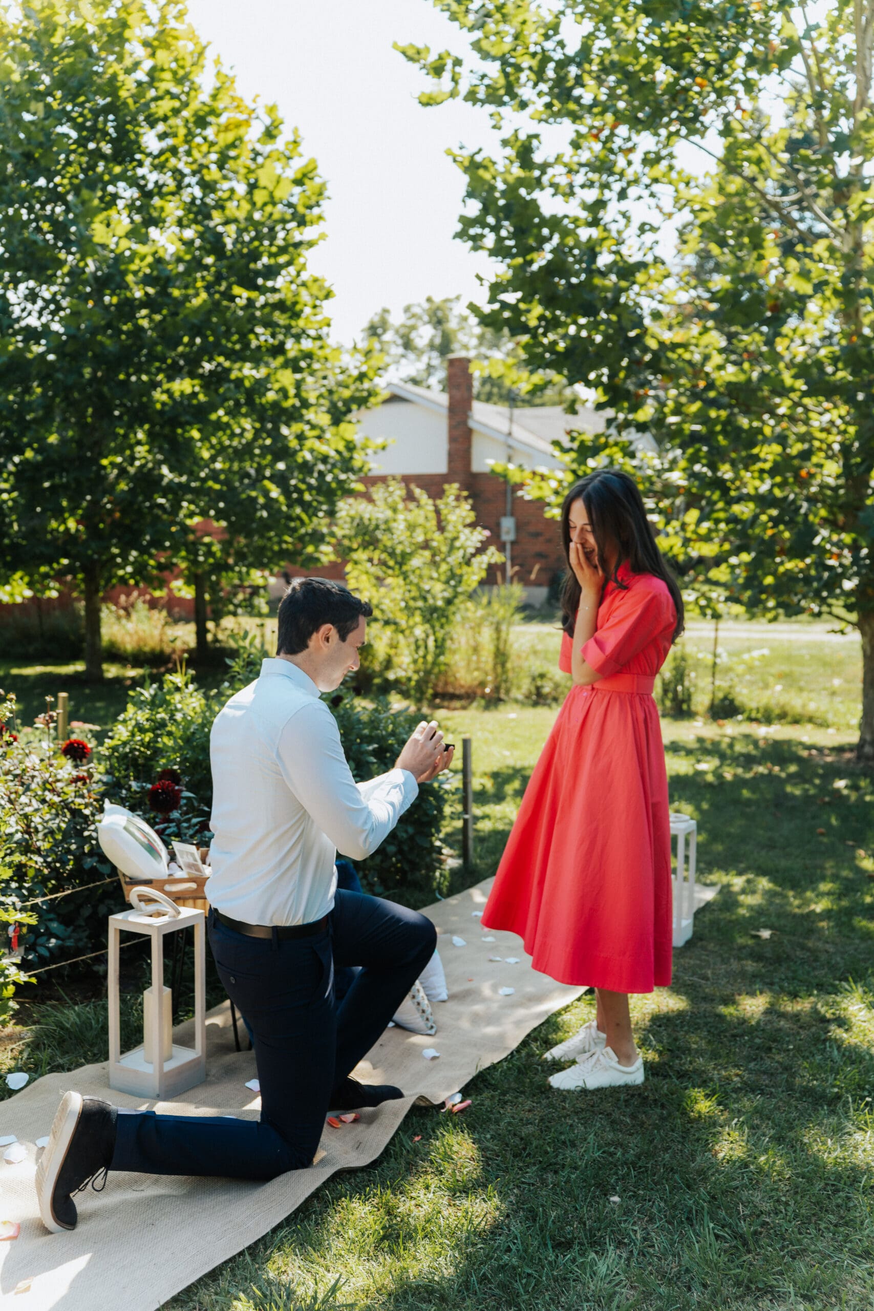 Man proposes to girlfriend wearing pink dress at All Who Wander Flower Farm in Hamilton, Ontario.
